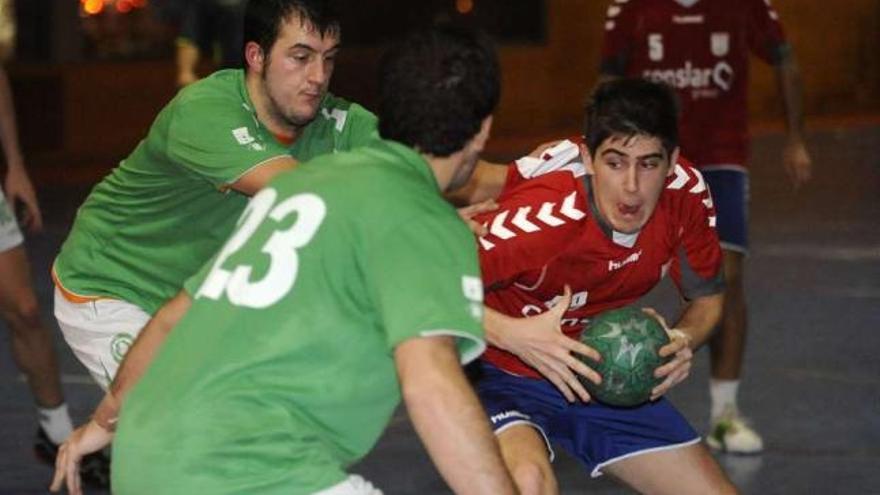 Un jugador del OAR esconde el balón defendido por dos rivales del SAR. / carlos pardellas