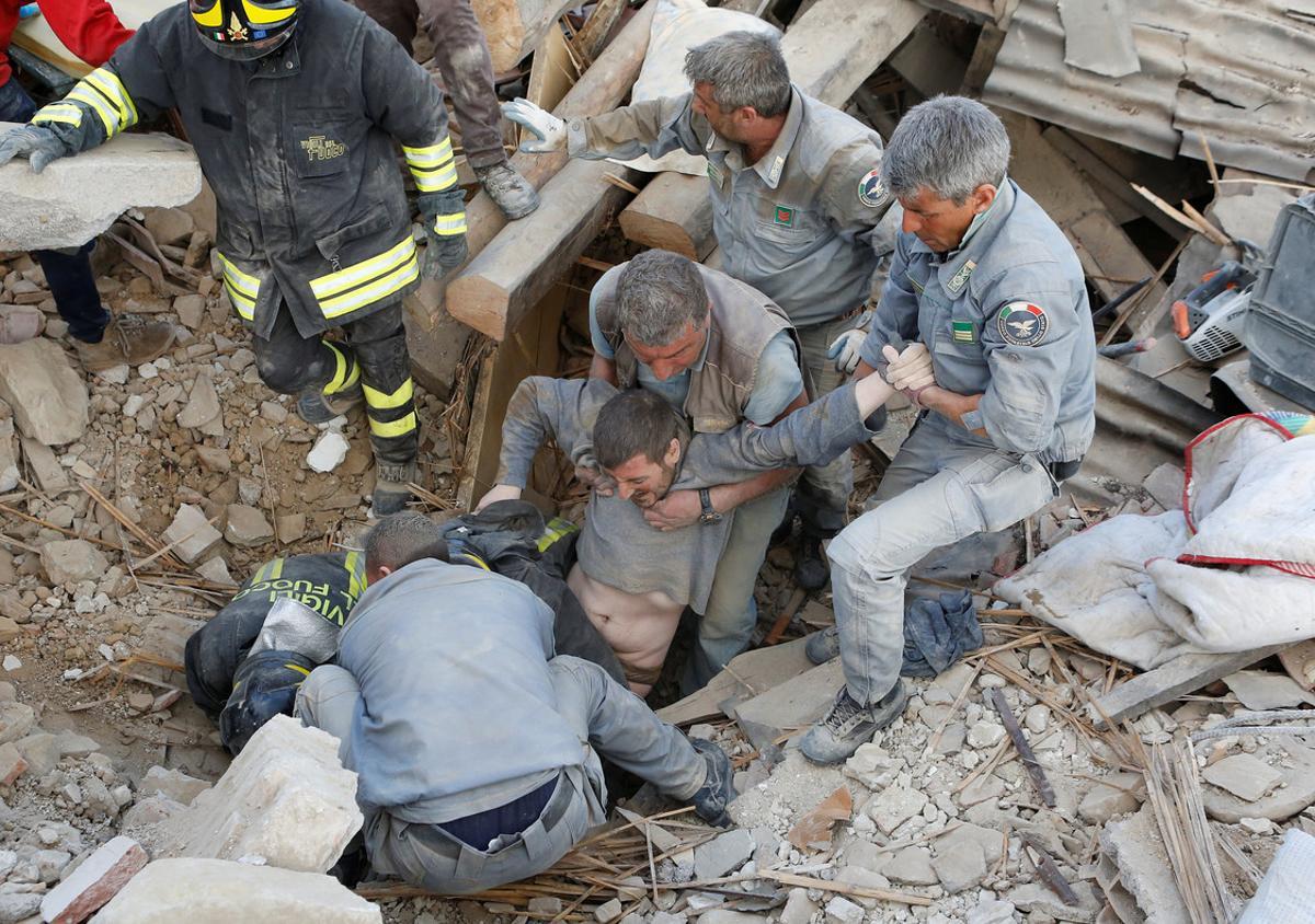 Un hombre es rescatado de entre los escombros en Amatrice, Italia.