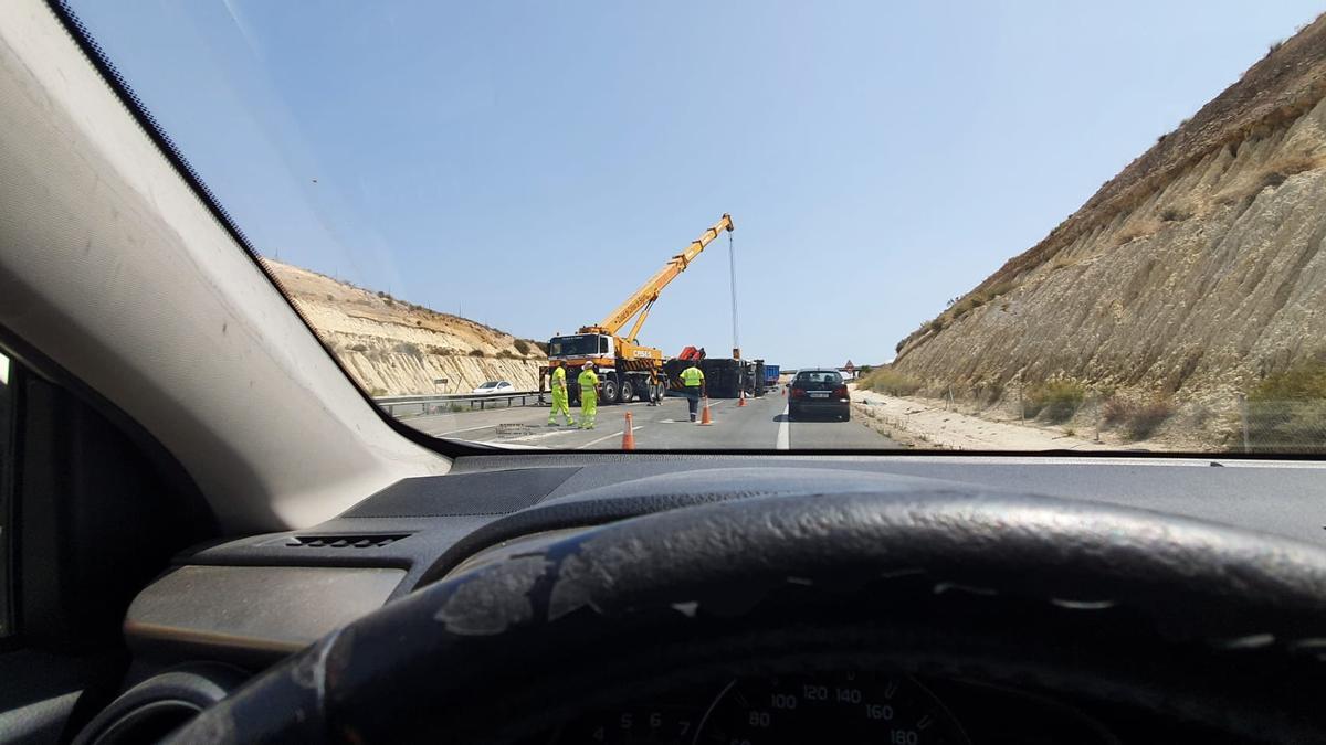 Trabajo de los bomberos para abrir de nuevo el tramo de autovía cerrado por el camión volcado en la A-7 en Elche