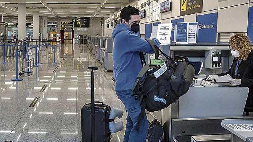 Un pasajero se dispone a introducir la maleta en la cinta durante el estado de alarma en el aeropuerto de Palma.