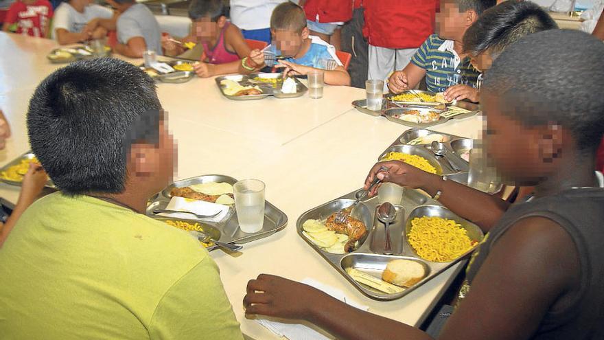 Los voluntarios de Cruz Roja, formados en la manipulación de alimentos, preparan además bolsitas de merienda para cada uno de los niños en la Escuela de Verano donde por primera vez y desde ayer pueden comer caliente al mediodía.