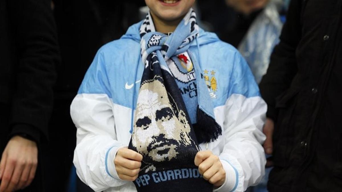 Una aficionada del Manchester City con una bufanda de Guardiola, vendida en las afueras del Etihad.