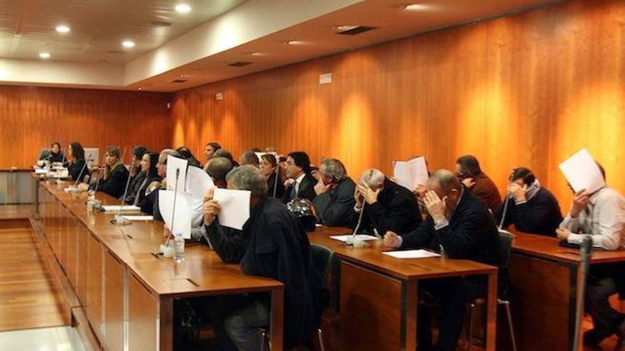 Los guardias civiles acusados en el juicio se tapan la cara para no ser fotografiados.