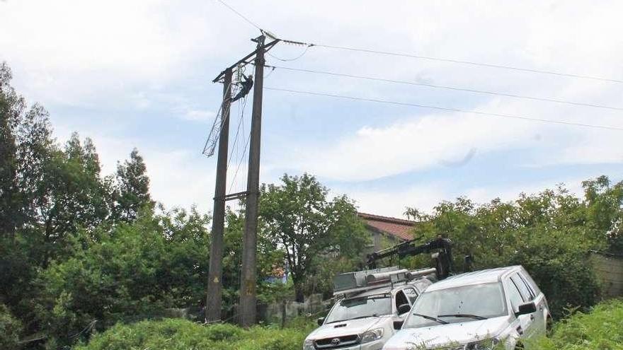 Los cables de alta tensión en A Gándara donde se partieron y, al fondo, la casa desalojada.  // Santos A.