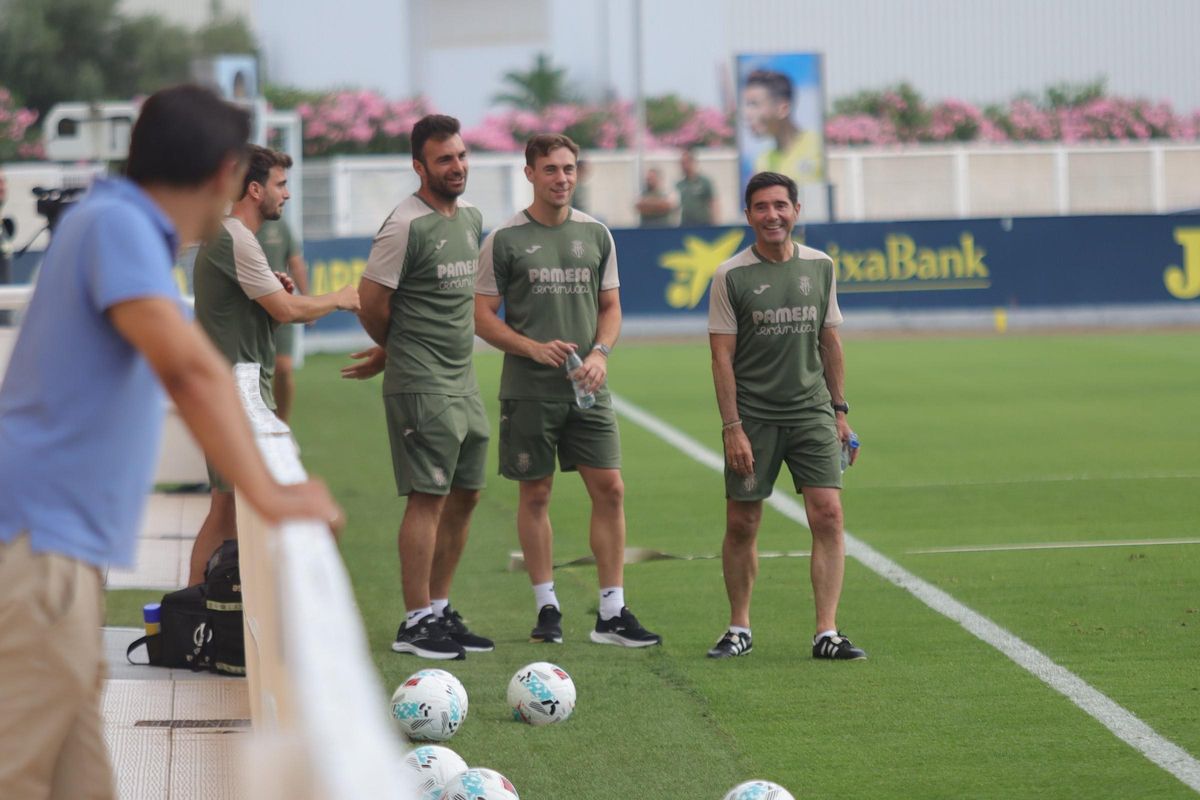 El entrenador del Villarreal, Marcelino García Toral (d), mira y sonríe al director de fútbol del Villarreal, Miguel Ángel Tena (difuminado a la izquierda).nto