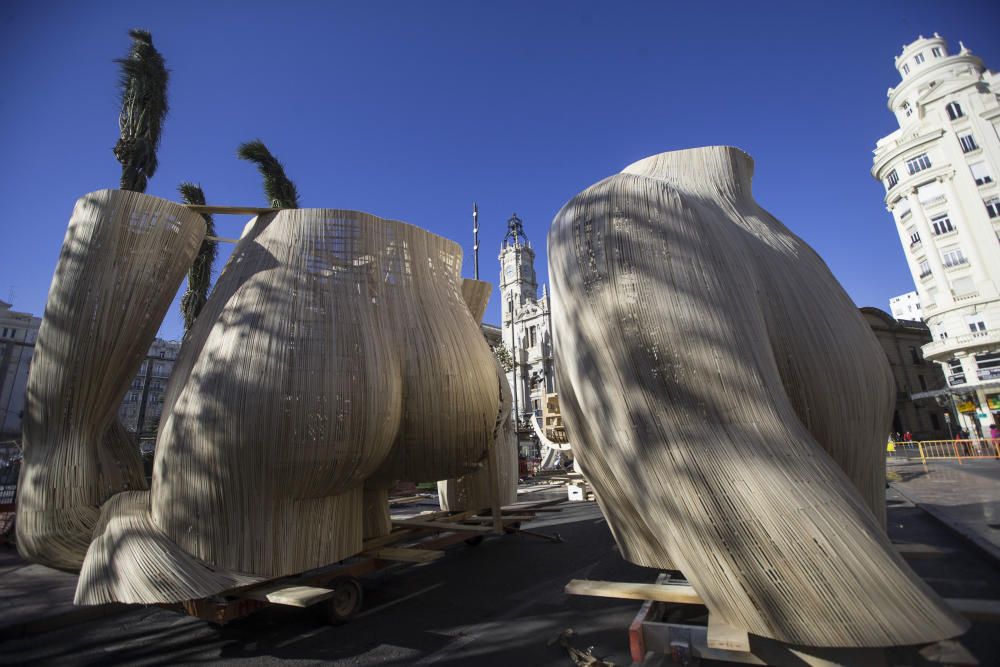 Los trabajadores del taller del artista fallero Manolo García preparan el izado de una de las piezas de la Falla de la Plaza del Ayuntamiento.