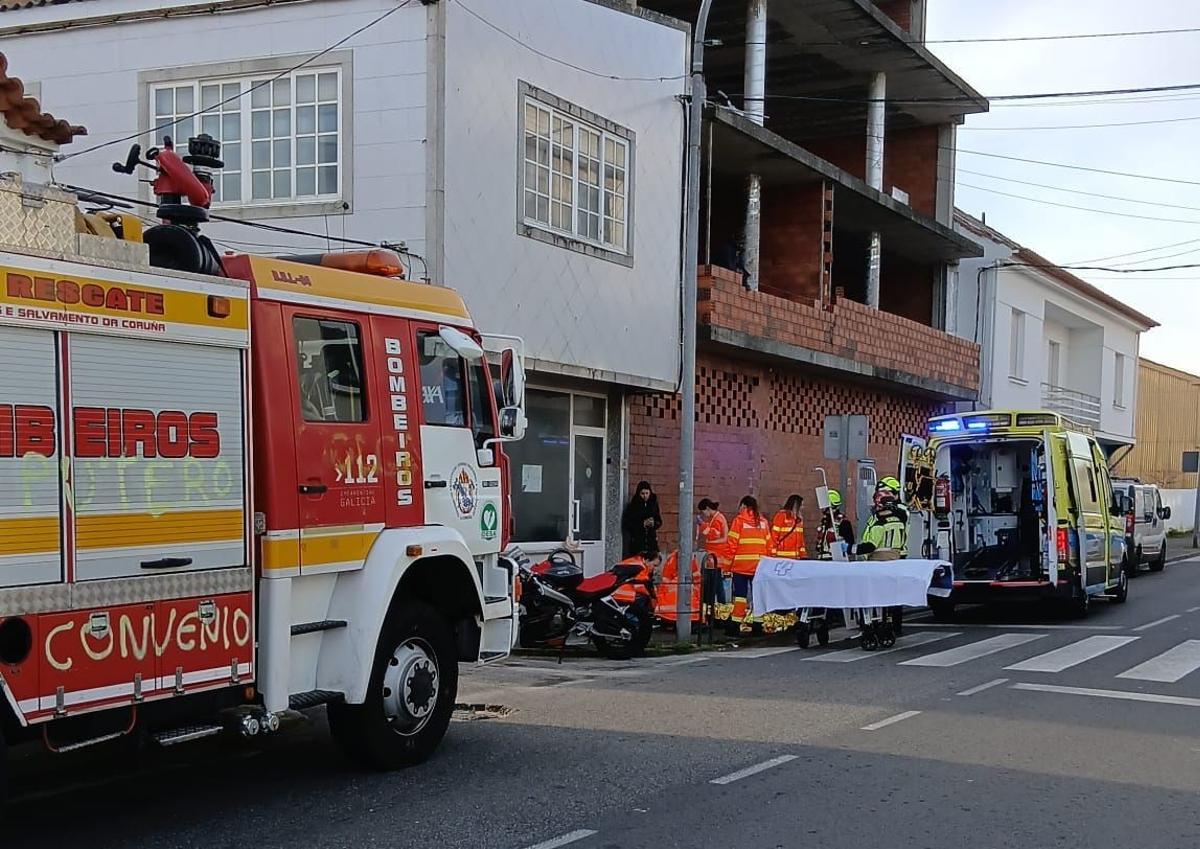 Sanitarios auxiliando al motorista herido en Aguiño.