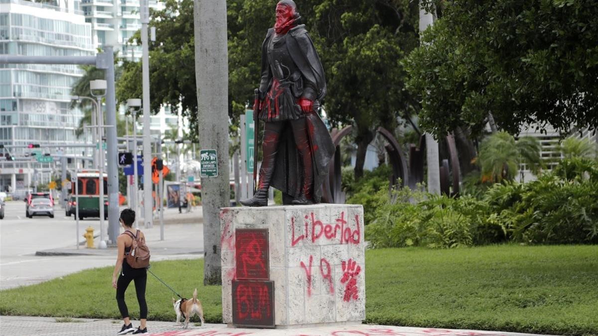 Una mujer pasa por una estatua de Juan Ponce en Miami, el 11 de junio del 2020