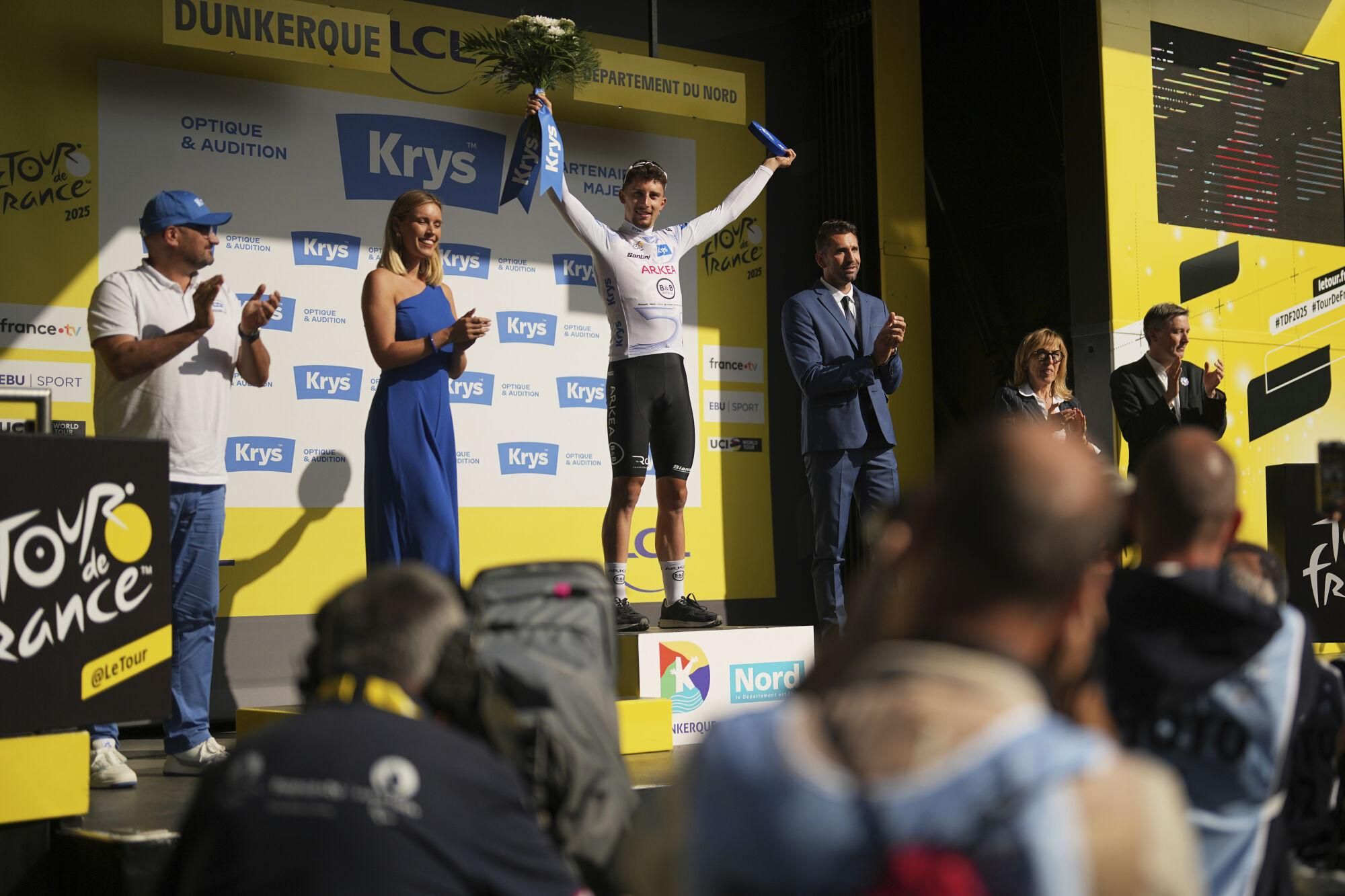 France's Kevin Vauquelin, wearing the best young rider's white jersey, celebrates on the podium after the third stage of the Tour de France cycling race over 178.3 kilometers (110.8 miles) with start in Valenciennes and finish in Dunkerque, France, Monday, July 7, 2025. (AP Photo/Thibault Camus)