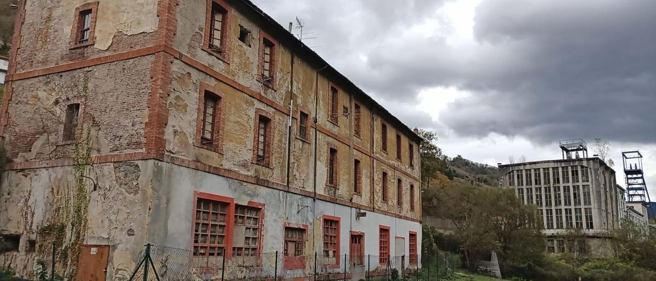 El edificio del economato del pozo Santa Bárbara, en primer término, con el resto de la explotación al fondo. | D. M.