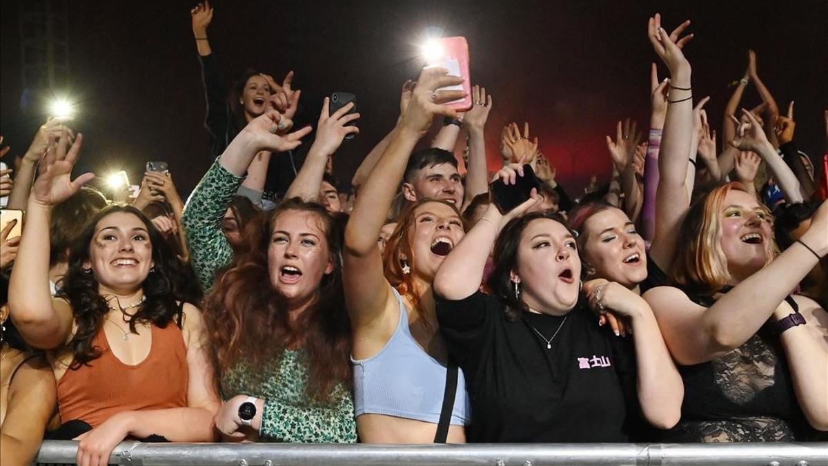Fans watch Blossom perform at a live music concert hosted by Festival Republic in Sefton Park in Liverpool  north-west England on May 2  2021  where a non-socially-distanced crowd of 5 000 are expected to attend  - A pilot programme to examine ways of putting on events in a post-covid-19 world will include a concert by the band Blossoms which will do away with social distancing  though audience members will have to provide proof of a negative coronavirus test before gaining entry  (Photo by Paul ELLIS   AFP)