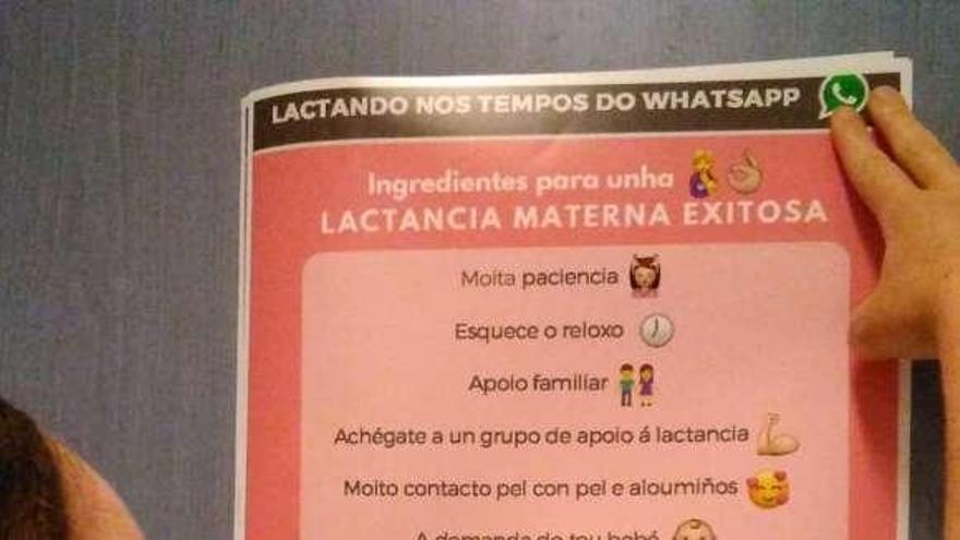 Una joven pega un cartel con la campaña de las matronas.