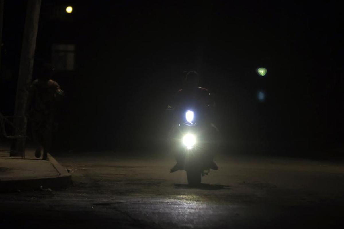 Un motociclista circula por una calle durante un apagón este jueves en La Habana, Cuba. La Unión Eléctrica (UNE) prevé nuevos cortes prolongados en toda la isla y estima que, en el momento de mayor demanda, hasta el 51 % del país podría quedarse simultáneamente sin suministro eléctrico.