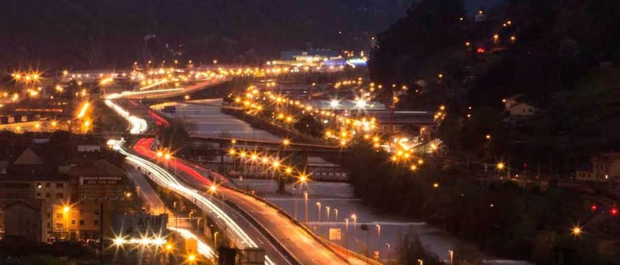 El enclave de las autovías de la Meseta y la Minera, en Mieres, en una vista nocturna, con el río Caudal.