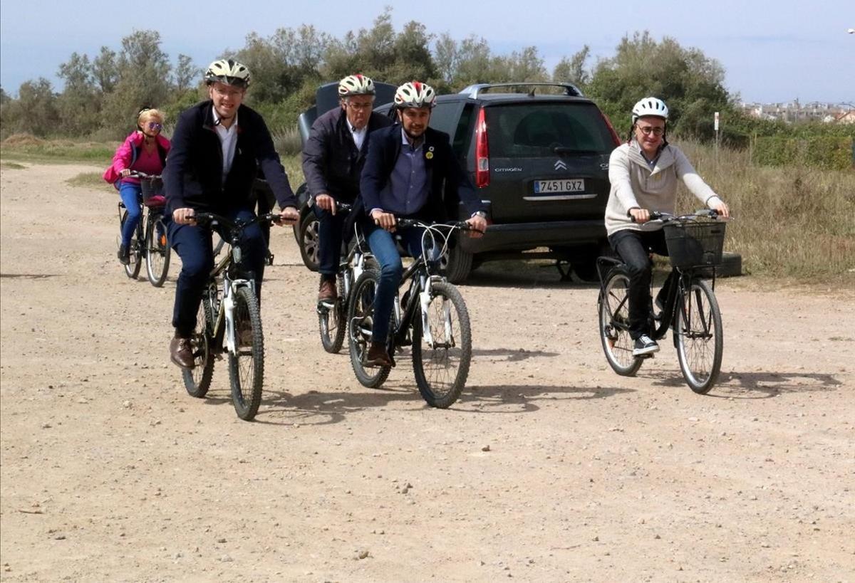 Los candidatos de JxCat, Ferran Bel y Ramon Tremosa, y el conseller de Territori i Sostenibilitat, Damià Calvet, paseando en bici por la playa de Creixell. 