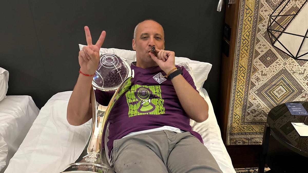 Antonio Vadillo posa en la cama de su habitación en Ereván con el trofeo de la Champions y fumándose un puro.