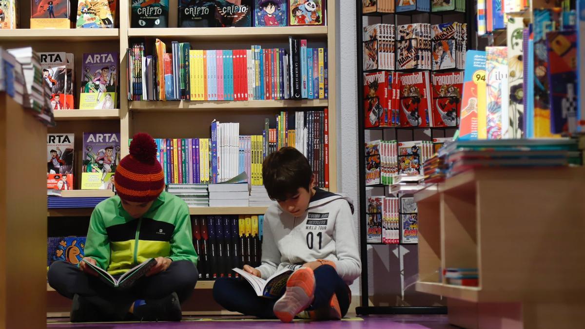 Dos chicos ojeando unos libros en La Casa del Libro.