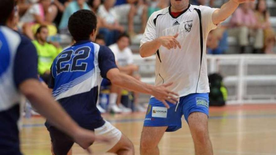 Miguel Porto pasa el balón ante la mirada de dos rivales en un partido en el Municipal. // Gustavo Santos