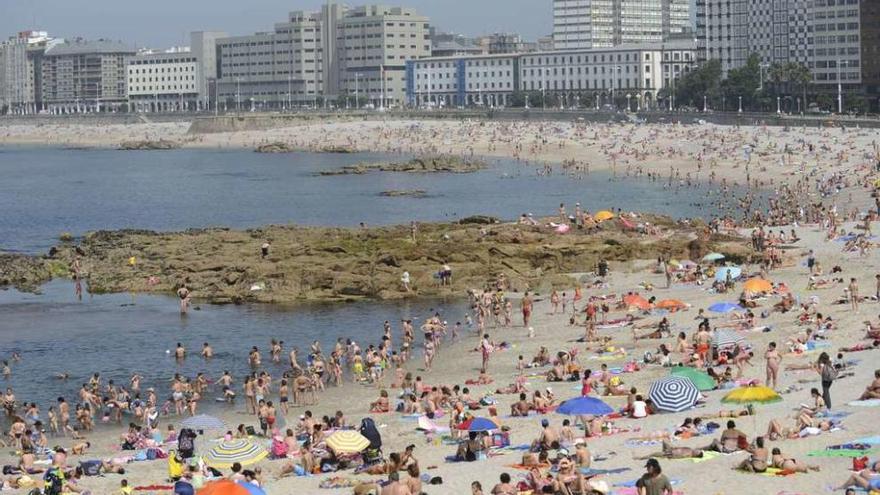 Bañistas toman el sol en la playa de Riazor de A Coruña.