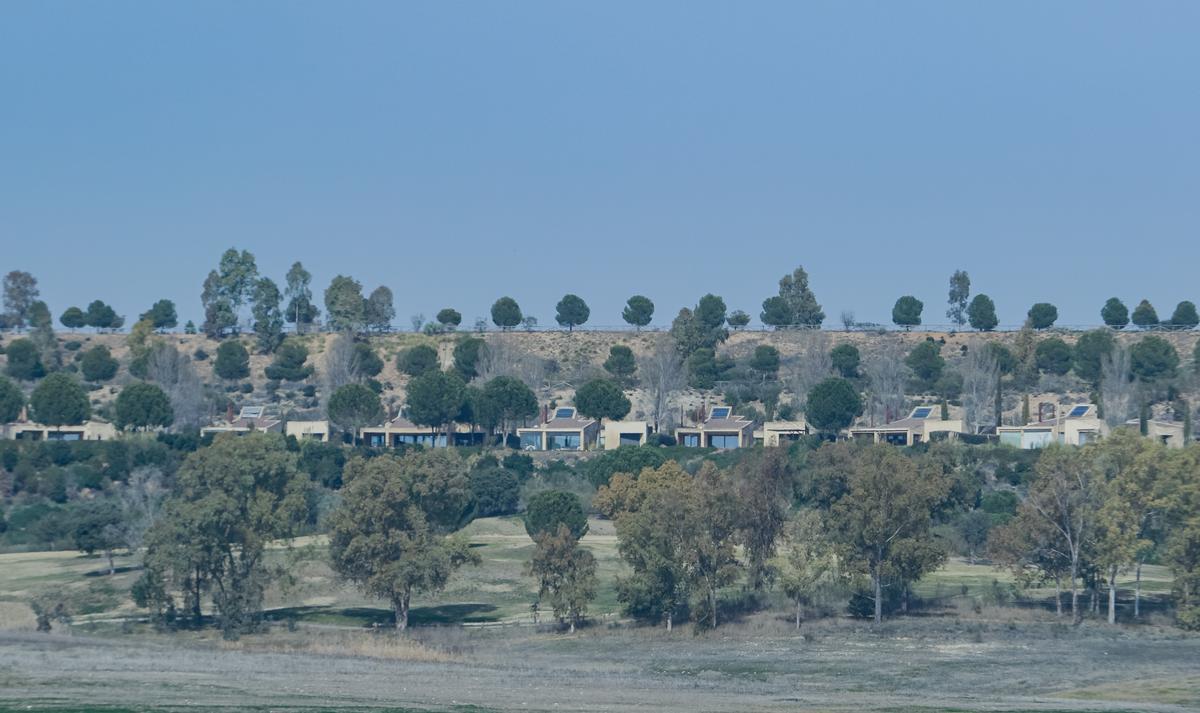Vista de algunas de las villas de Isla Valdecañas desde la otra orilla del embalse.