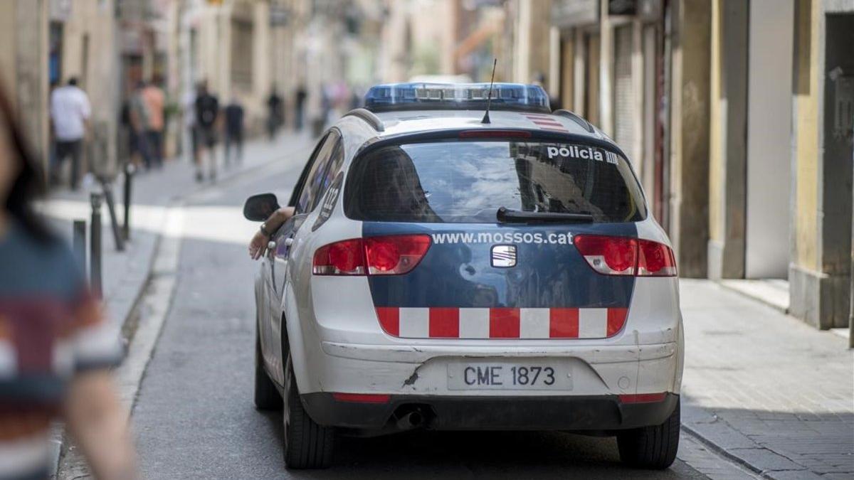 Un coche de los Mossos patrulla por una calle dl Raval