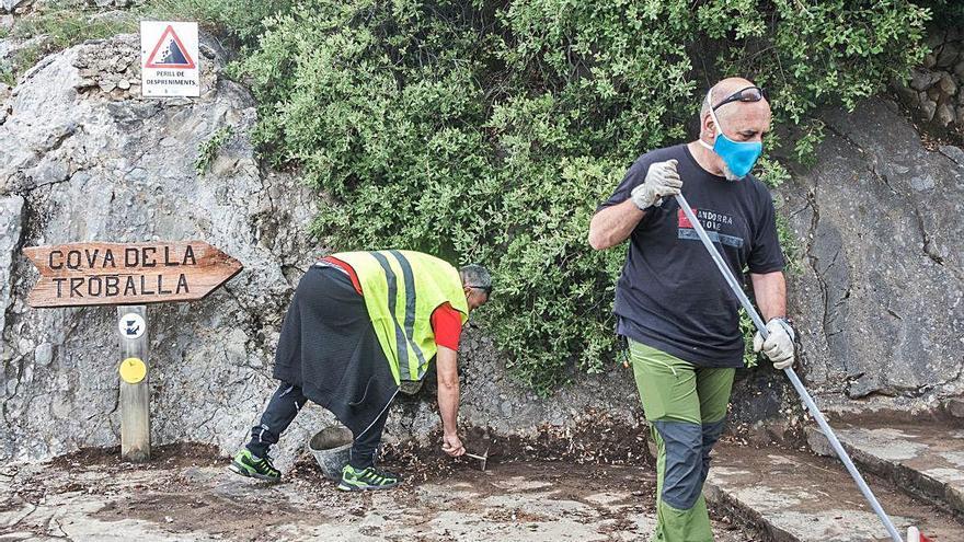 Neteja a les escales del camí de la cova de la Troballa