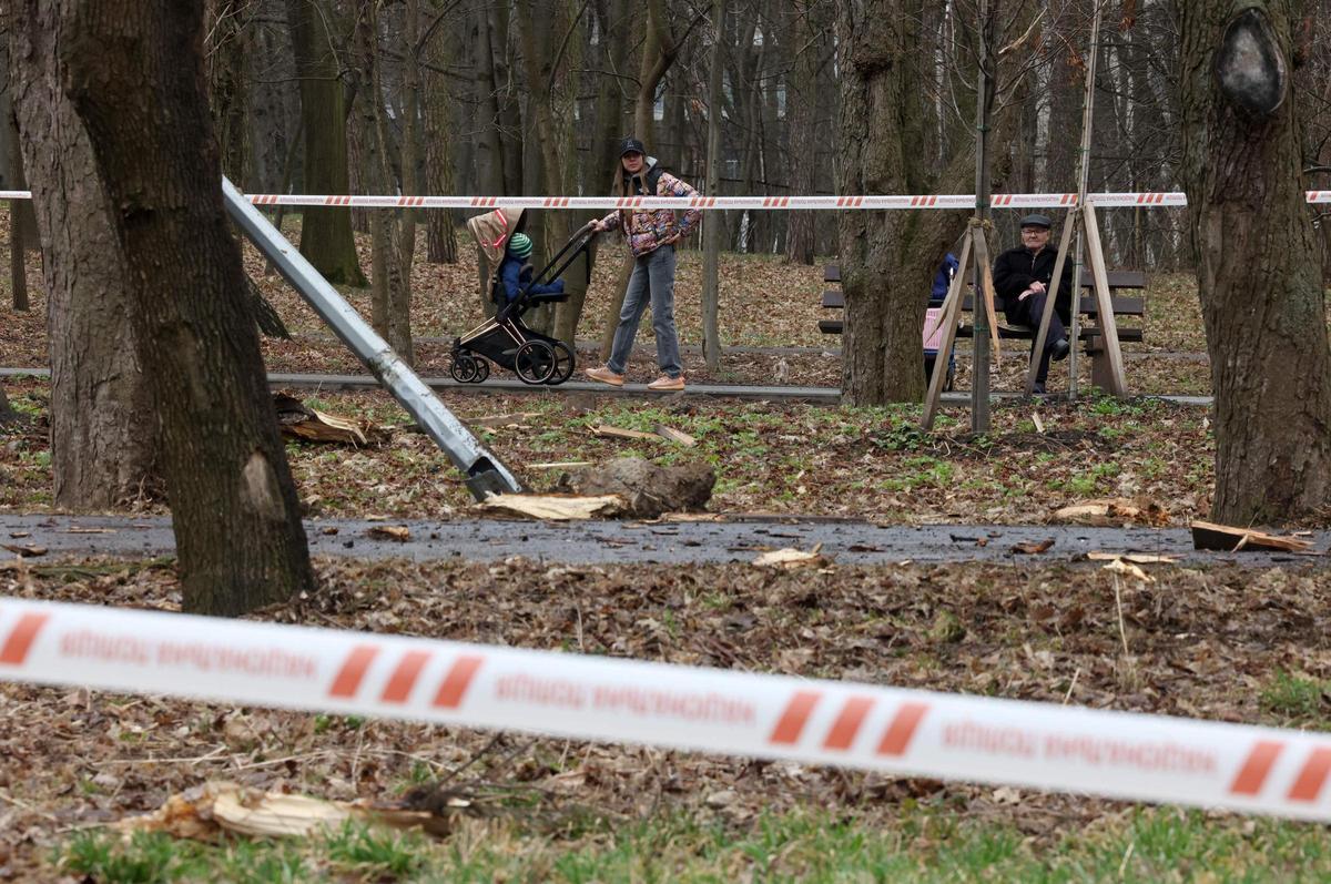 Los residentes locales caminan cerca del lugar del ataque con cohetes en uno de los parques después de un ataque con misiles rusos en Kiev.