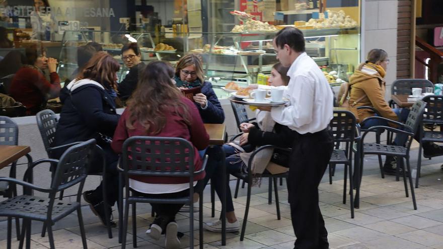 Un camarero sirve una mesa en una cafetería de la calle Major de Gandia. | XIMO FERRI