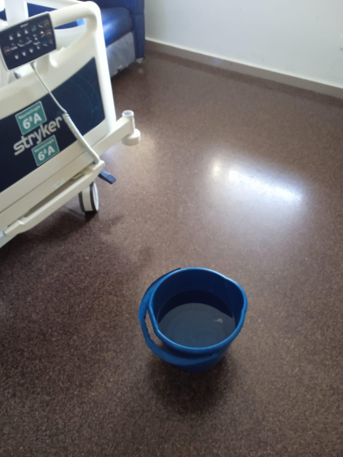 Uno de los cubos con agua para asear a pacientes que el personal lleva de otras zonas del hospital