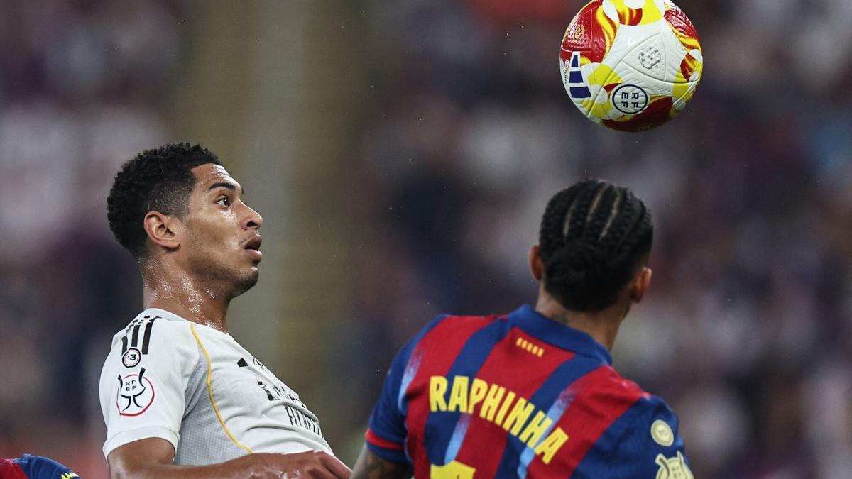 Jude Bellingham (izquierda) y Raphinha (derecha) pelean un balón.