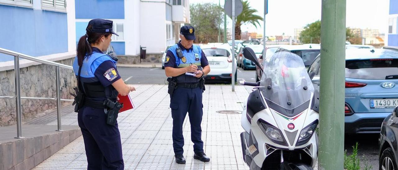 Un policía local toma los datos de una moto mal aparcada.