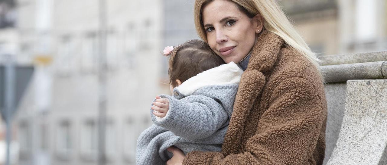 Tamara Domínguez, junto a su hija de 14 meses en la plaza del Mercado de Teis. / Ricardo Grobas