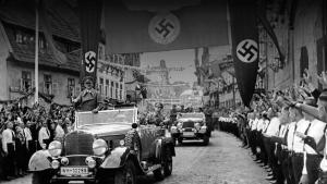 Civiles haciendo el saludo nazi ante el paso de Hitler durante un desfile.