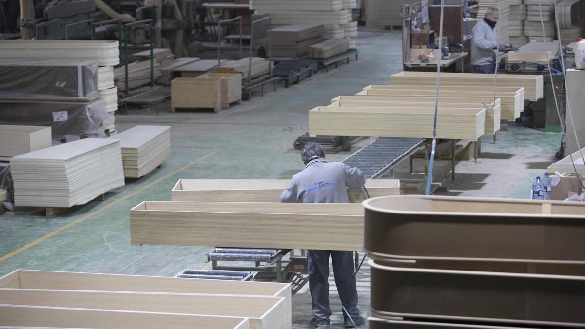 Empleados trabajando en una fábrica de arcas fúnebres en Xàtiva.
