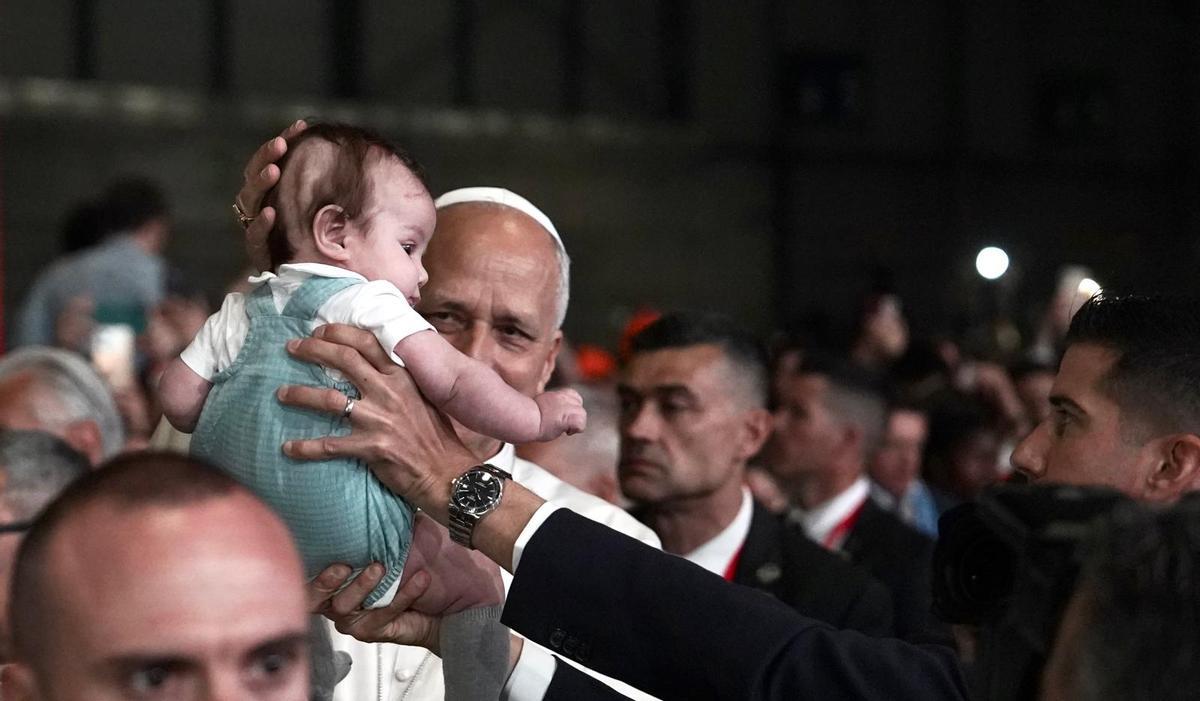 León XIV bendice a un niño.