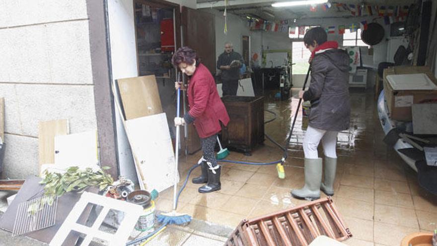 Vecinos de Redondela limpian sus hogares tras las inundaciones // R.Grobas