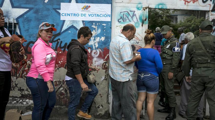 Varias personas asisten a un centro de votación en Caracas.