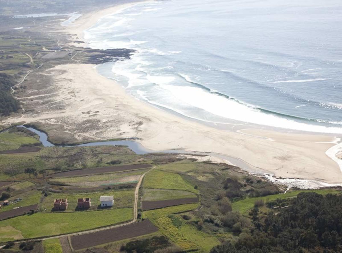 Vista aérea de la playa de Río Sieira, en Porto do Son, con la formación rocosa que la separa de la playa de As Furnas