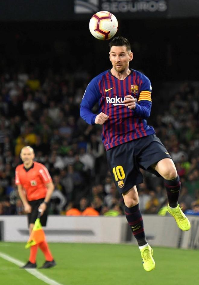 Leo Messi, cabecea el balón durante el encuentro correspondiente a la jornada 28 de primera división que disputan esta noche frente al Real Betis en el estadio Benito Villamarín, en Sevilla.