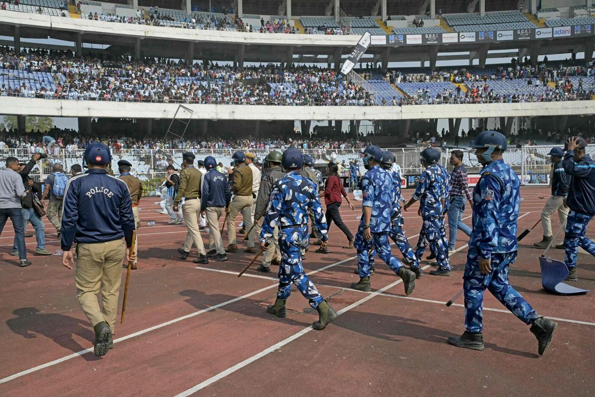 Security personnel try to control the crowd as Inter Miamis Argentine forward #10 Lionel Messi departs from the Salt Lake Stadium in Kolkata on December 13, 2025. Thousands of fans packed into a stadium in eastern India on December 13 to cheer on Lionel Messi as the football legend unveiled a 21-metre (70-foot) statue of himself. (Photo by Dibyangshu SARKAR / AFP)