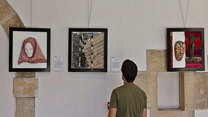 Un joven observa varias de las máscaras instalada en el claustro del Colegio Universitario.