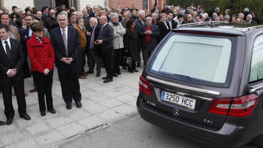 Las autoridades, en primer plano, y decenas de personas, despiden el coche fúnebre de Miguel Navarro