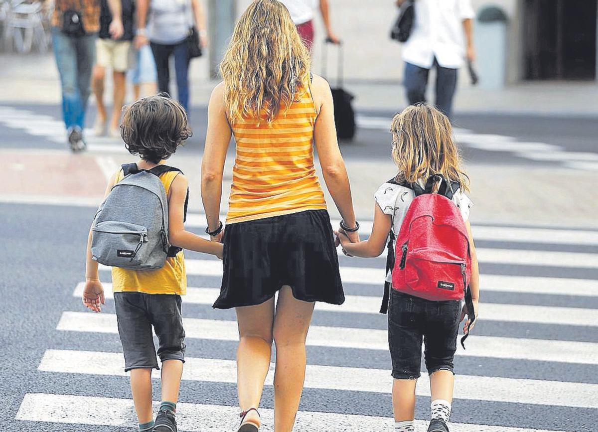 Una madre acompaña a sus hijos al colegio