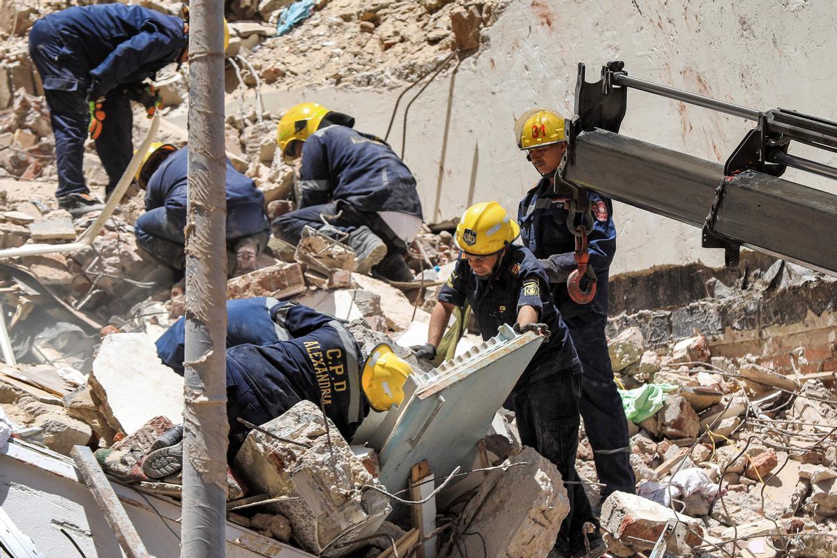 Los socorristas de defensa civil buscan entre los escombros en la escena de un edificio derrumbado de 13 pisos en el distrito de Sidi Bishr de la ciudad de Alejandría, en el norte de Egipto.