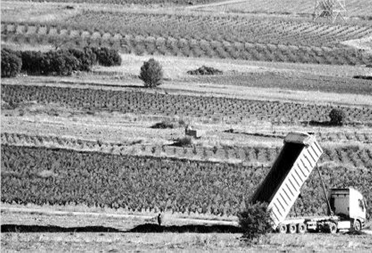 Un camión vierte lodo sin secar procedente de Emarsa en un campo de El Rebollar.