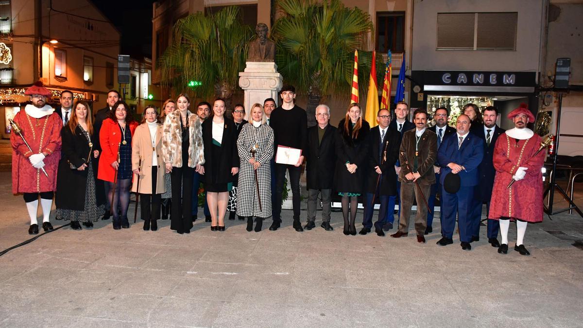 Foto de familia de la corporación municipal y la corte de honor en la plaza Bayarri, junto al busto de Tàrrega.