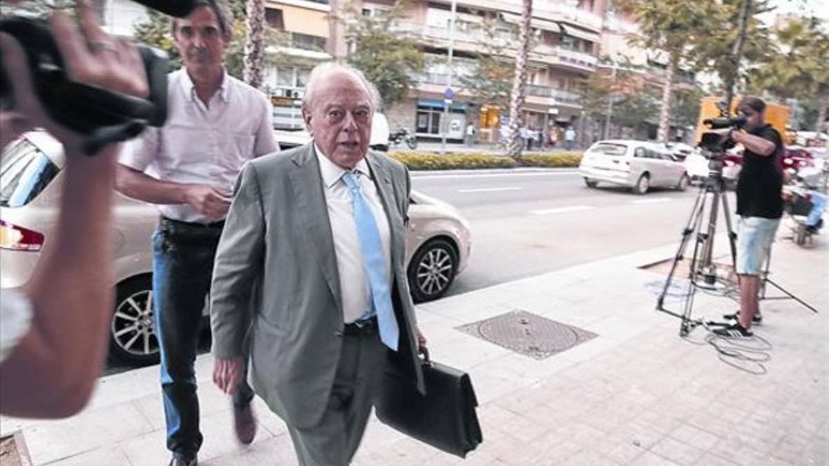 Jordi Pujol llega a su casa el pasado 1 de septiembre, con un calcetín en la mano tras sufrir un esguince en un pie.