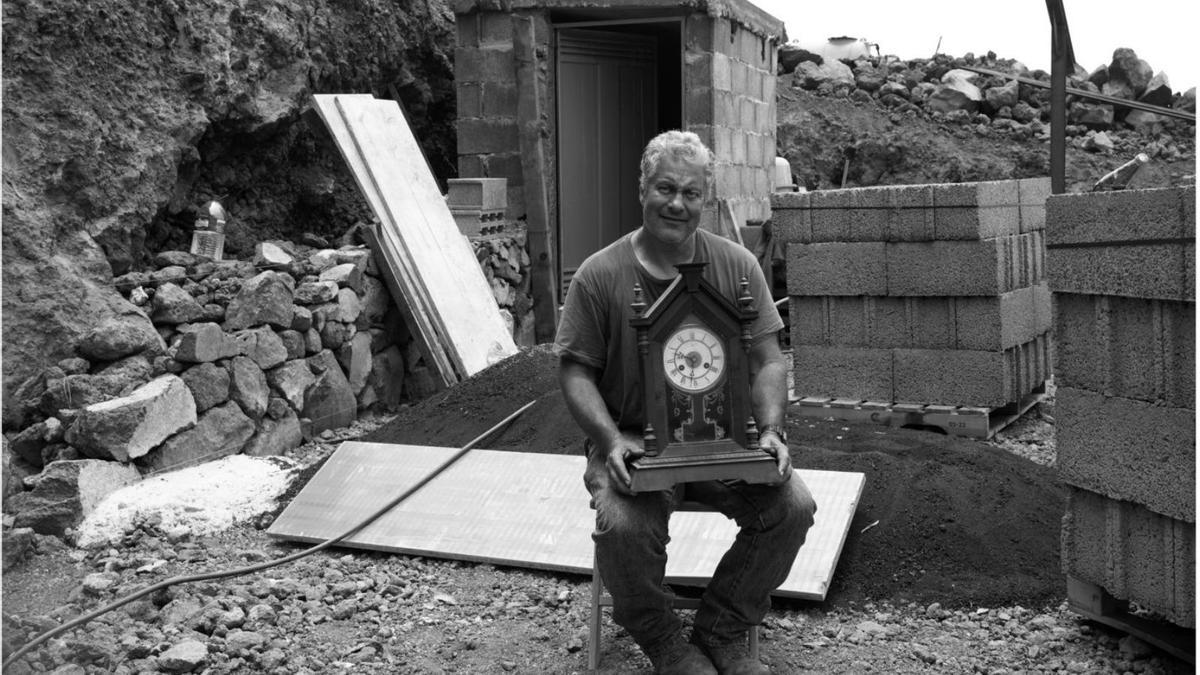 El agricultor Luis, en La Palma, con el reloj que rescató de la erupción del volcán de Cumbre Vieja. | | TERESA CORREA E IZABELLA JAGIELLO