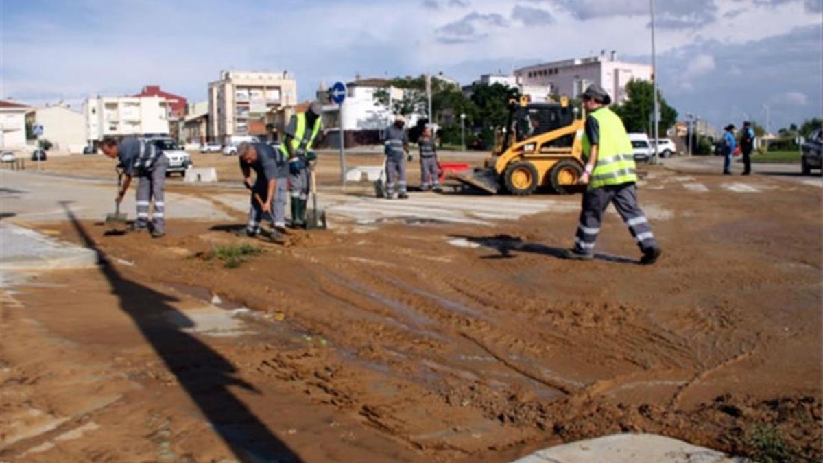 Limpieza de una calle de Cassa de la Selva inundada de barro