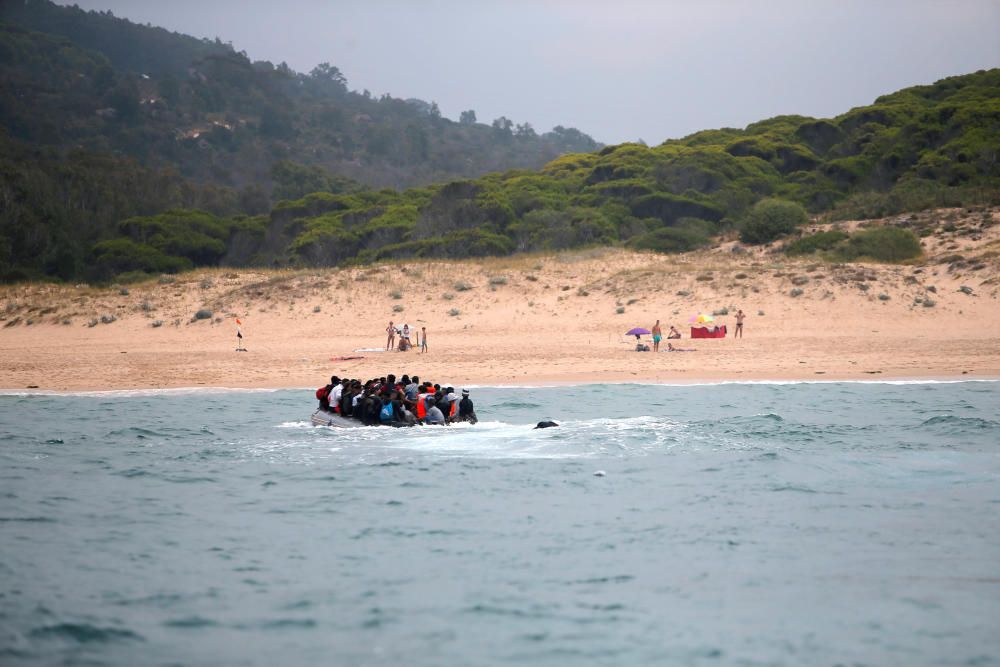 Una patera llega a una playa de Cádiz ante la mirada de los bañistas